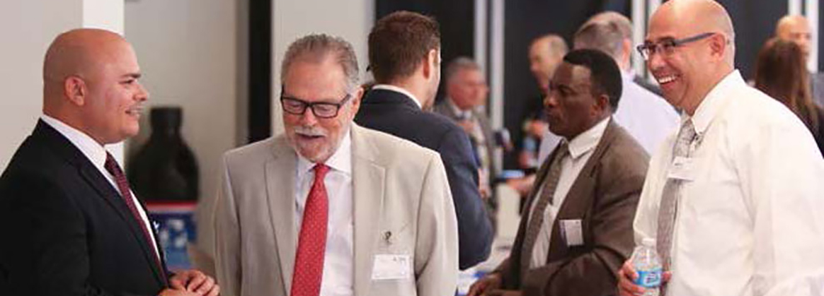 NSWC Corona’s Thomas Beauchamp (left) talks to visitors at a corona university event.